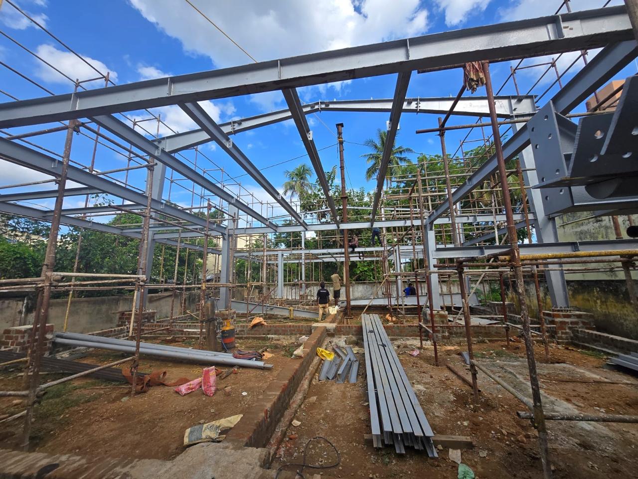 Scaffolding, rafters, and structural steel framework under erection